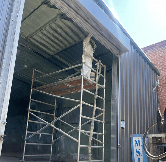 insulation installation on a high building using a rolling scaffold